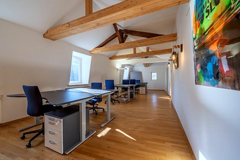 Arbeitsplätze unter Holzbalken in der Villa Michels